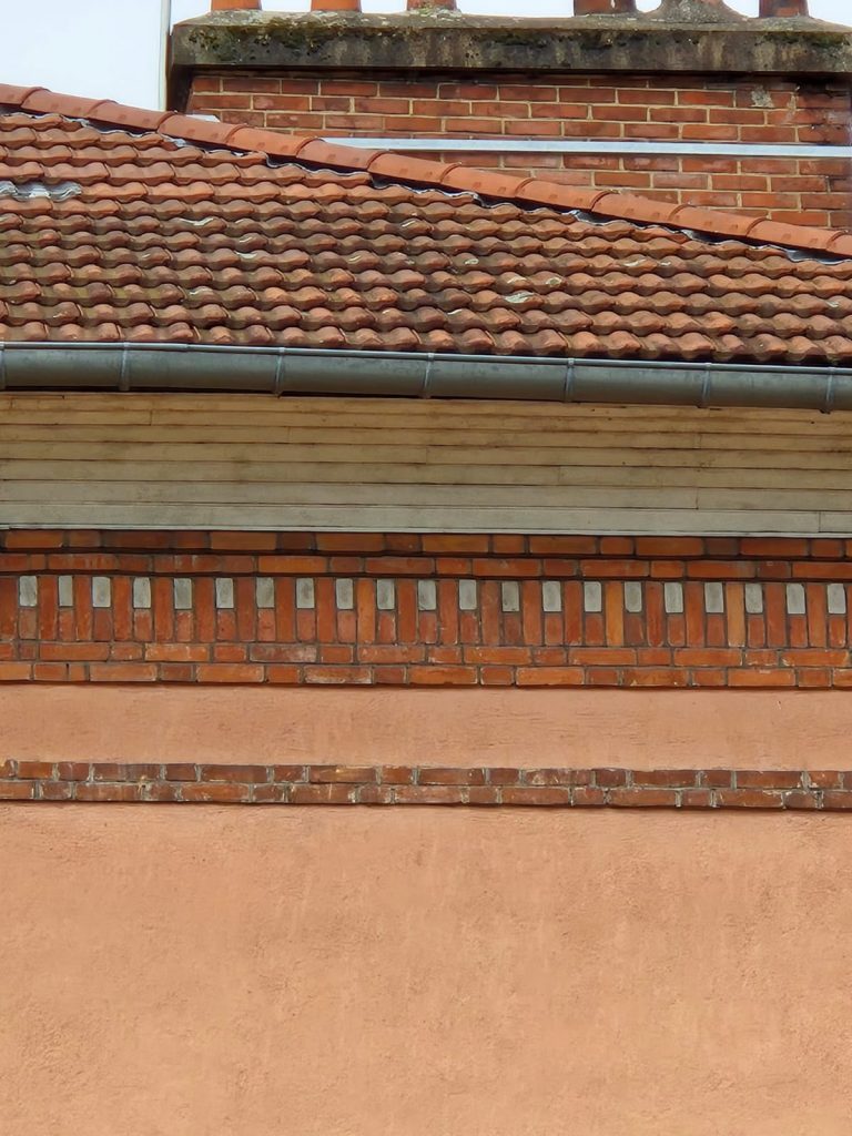 Détail des décors en briquesur le haut des murs d'un bâtiment 4 pans de 1933