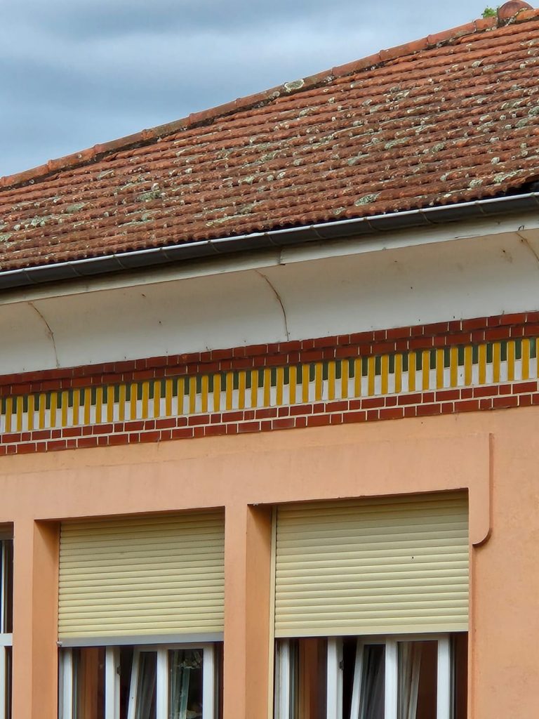 Détail des décors en céramique peinte sur le haut des murs à l'école Gauguin de 1933